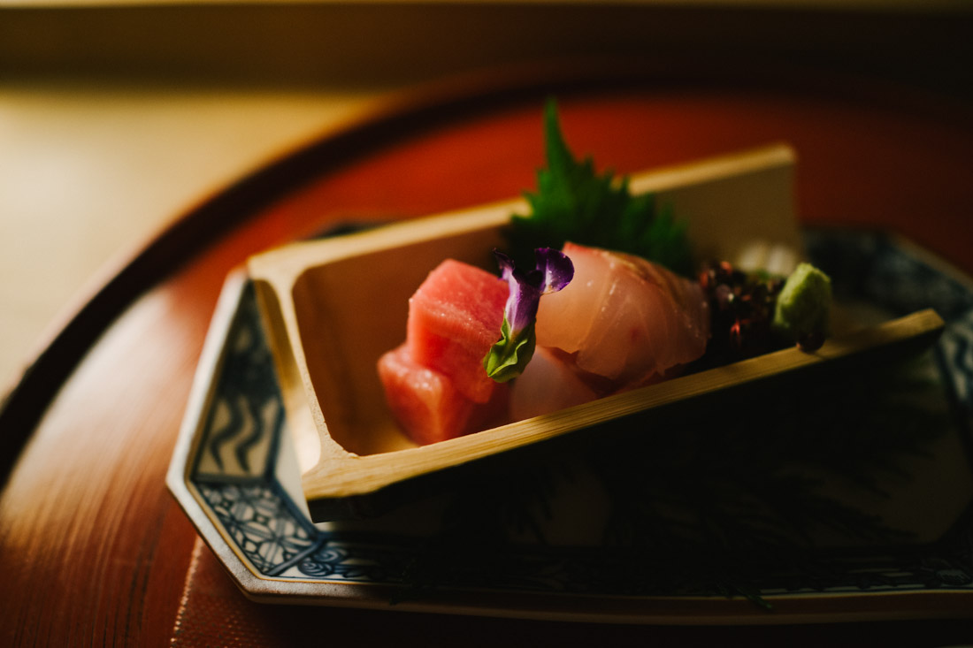 Sushi tasting inside bamboo: two types of tuna, salmon, squid and halibut.