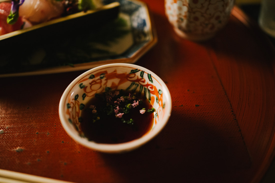 Soy sauce with tiny flower petals.